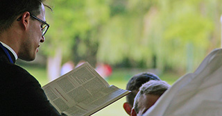Priester aus Bibel vorlesend